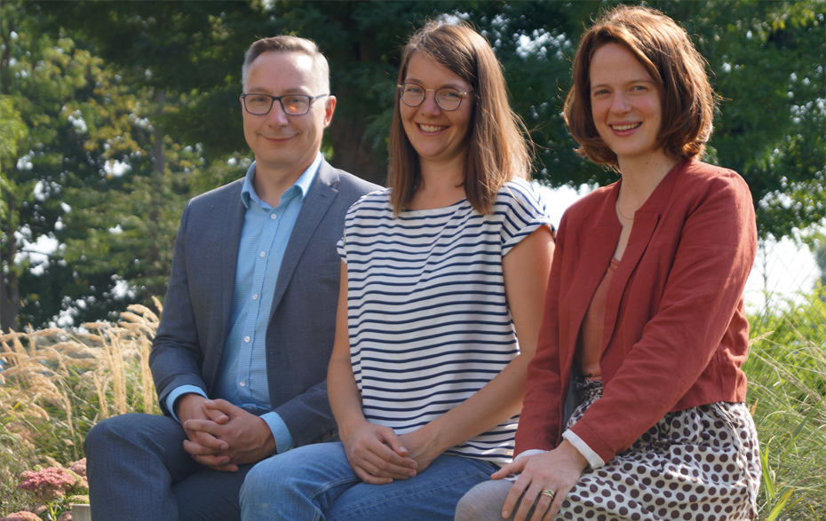 Foto: 3 Personen sitzen auf einer Bank