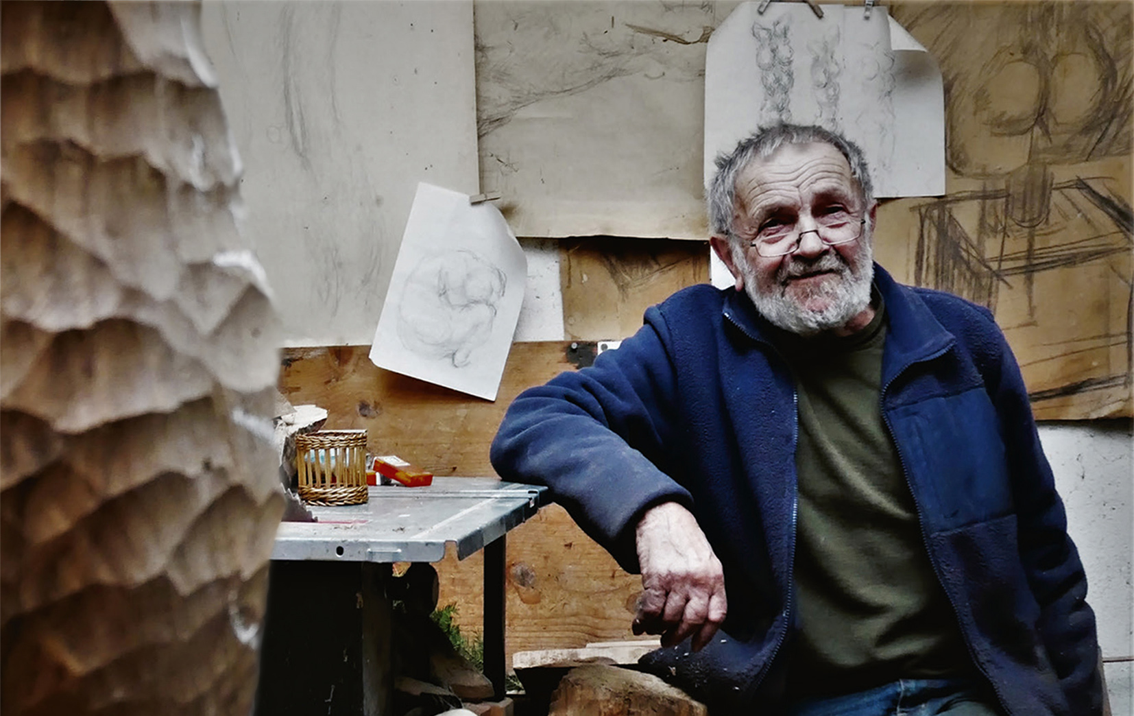 Foto: Künstler vor einer Wand mit Zeichnungen