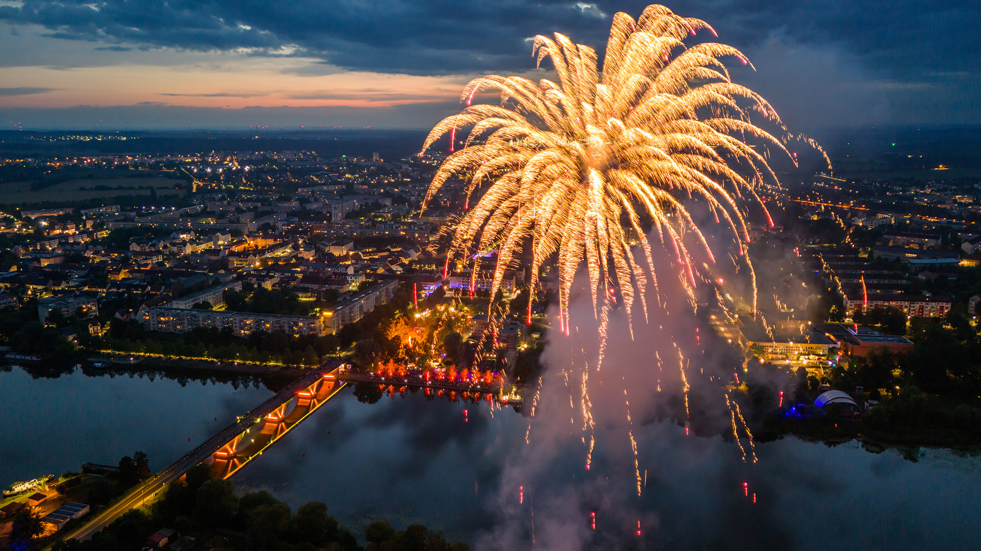 Luftbild mit Feuerwerk vor der abendliche Stadtsilhouette