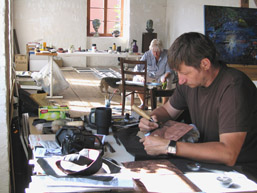 Foto: zwei Künstler in einer Galerie beim Wirken am Arbeitsplatz