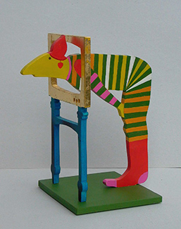 Foto: Die Holzskulptur zeigt eine bunte Figur, die gebückt dasteht und den Kopf durch ein Fenster steckt . Foto: Die Holzskulptur zeigt eine bunte Figur, die gebückt dasteht und den Kopf durch ein Fenster steckt .