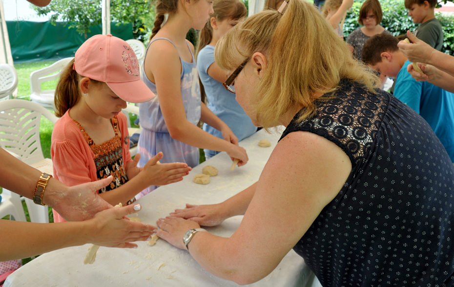 Foto: Kinder formen Teig unter Anleitung