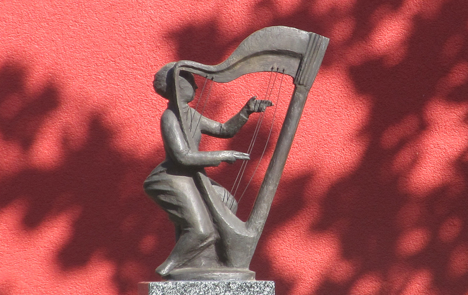 Foto: Bronzeplastik vor einer roten Wand