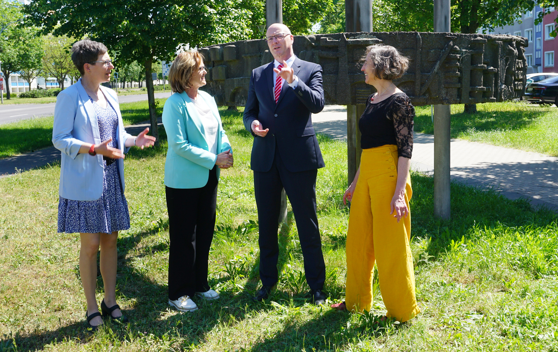 Foto: 4 Personen vor der Ringstele