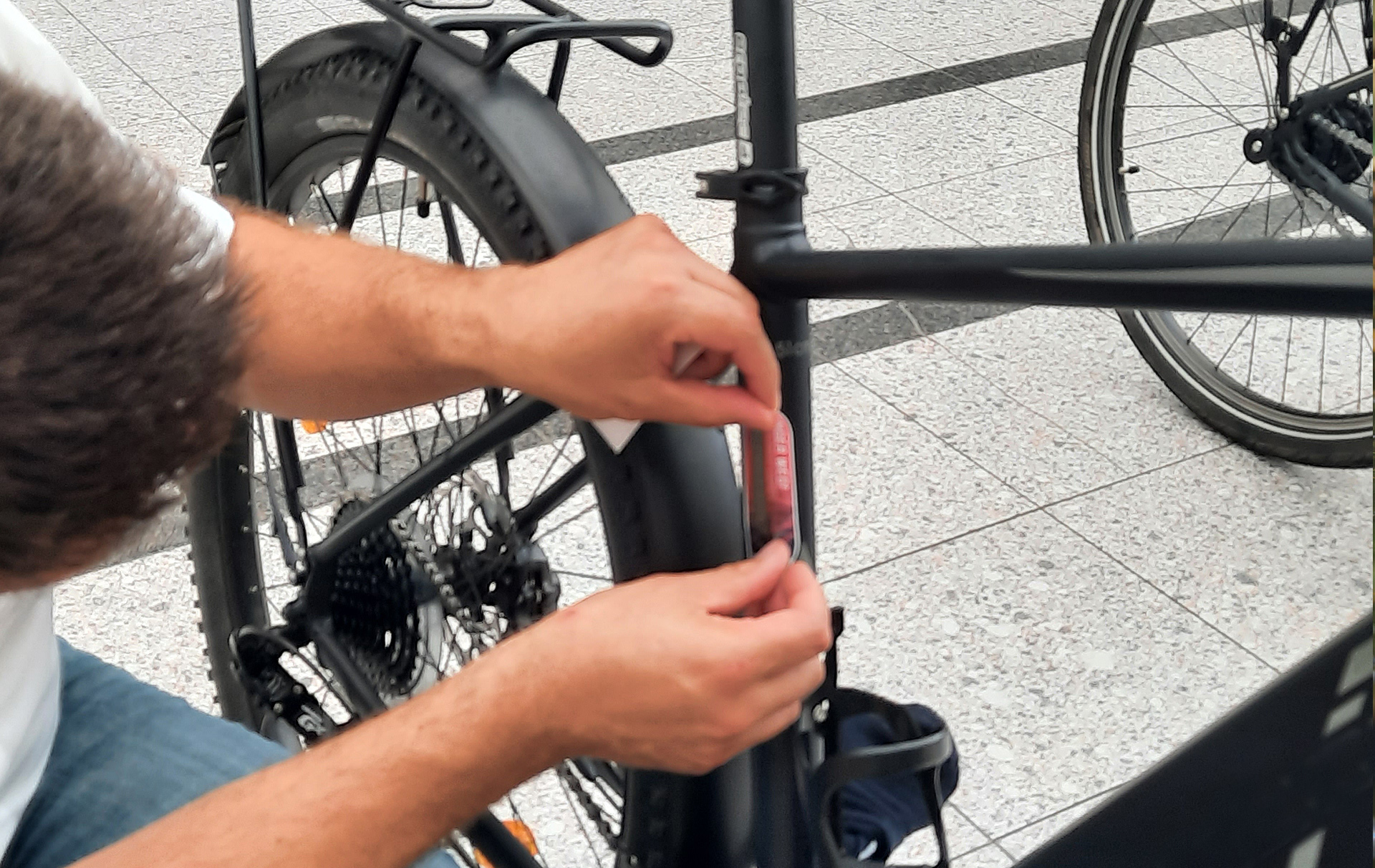 Foto: an einem Fahrrad wird der Aufkleber angebracht Foto: an einem Fahrrad wird der Aufkleber angebracht