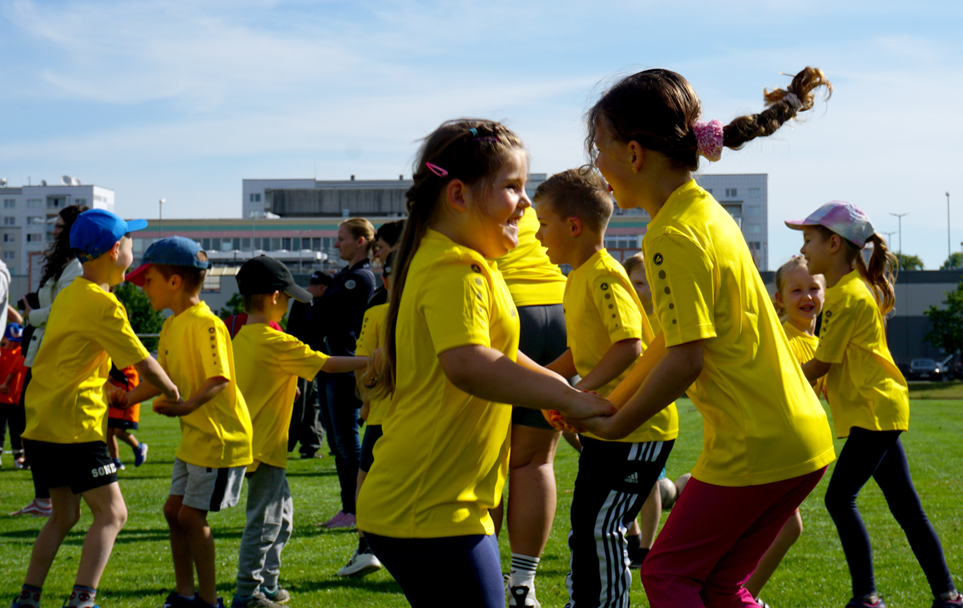 Foto: tanzende Kinder in gelben T-Shirts