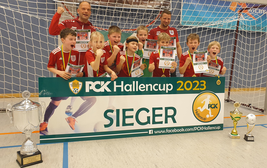 Gruppenfoto in Siergerpose mit Urkunde, Pokalen und Medaillen