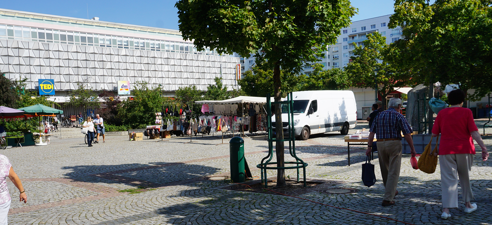 Foto: Platz der Befreiung am Markttag mit Ständen und Besuchern.