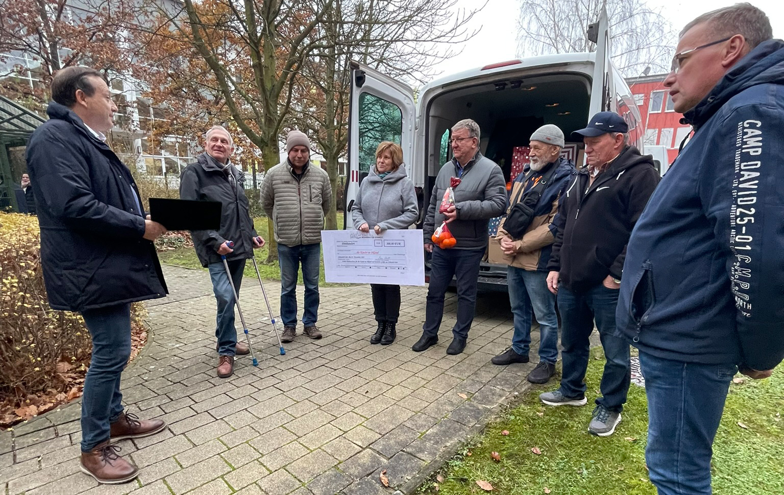Gruppenfoto vor den Wagen voller Weihnachtspäckchen