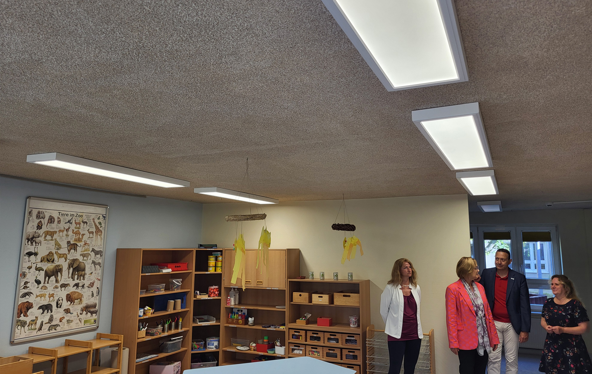 Foto: 4 Personen besichtigen die Räume mit der neuen Beleuchtung