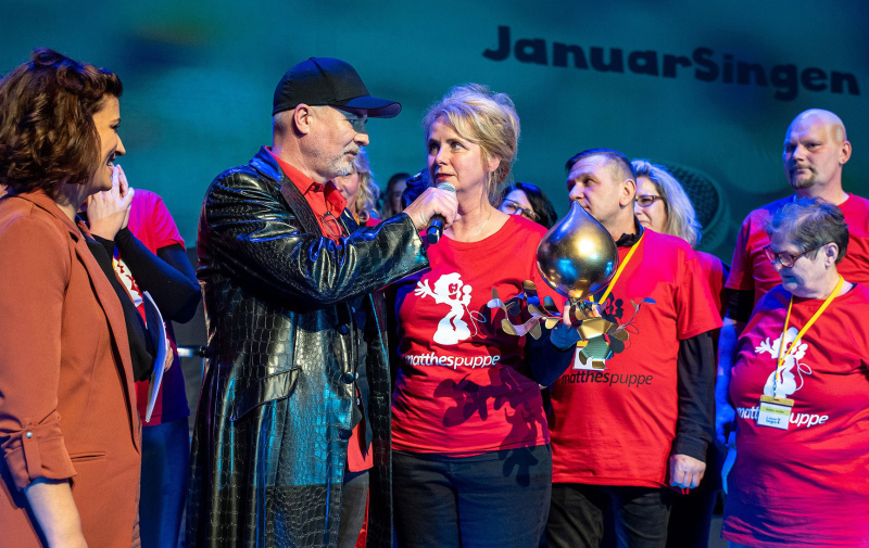 Foto: Das Siegerteam mit der Siegertrophäe wird interviewt