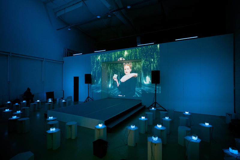 Foto: Bildschirm an der Bühnenrückwand und leuchtende Cubes für die Interaktion