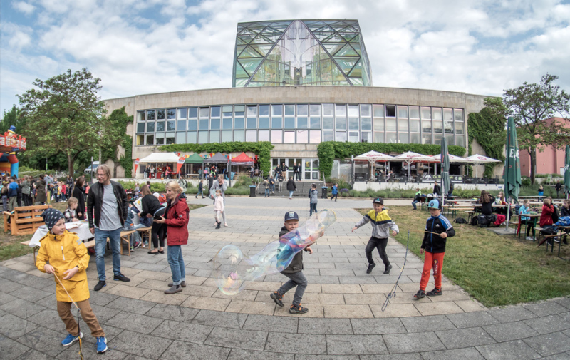 Foto: Kinder mit Riesenseifenblasen hinter den ubs
