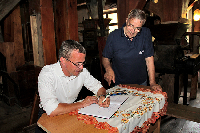 Wirtschaftsminister Albrecht Gerber trägt sich ins Gästebuch der Kanow-Mühle Sagritz ein.
